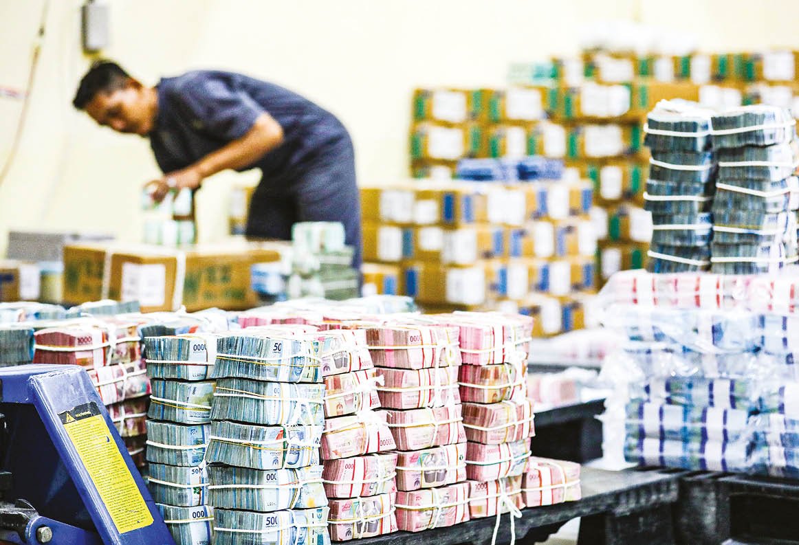 Bisnis/Himawan L Nugraha Pegawai menyortir uang rupiah di cash center atau pusat kas BNI di Jakarta.